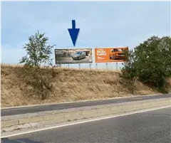 Cartel de gran formato en la Ronda Norte de Leganés, con la calle Atenas enfrente y el parque comercial Plaza Nueva como destino